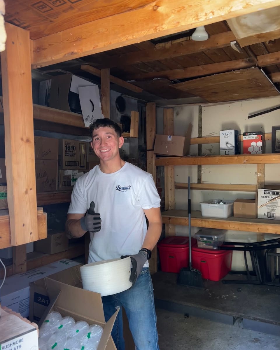 Benny in a Benny's Junk Co shirt giving a thumbs up during a shed cleanout