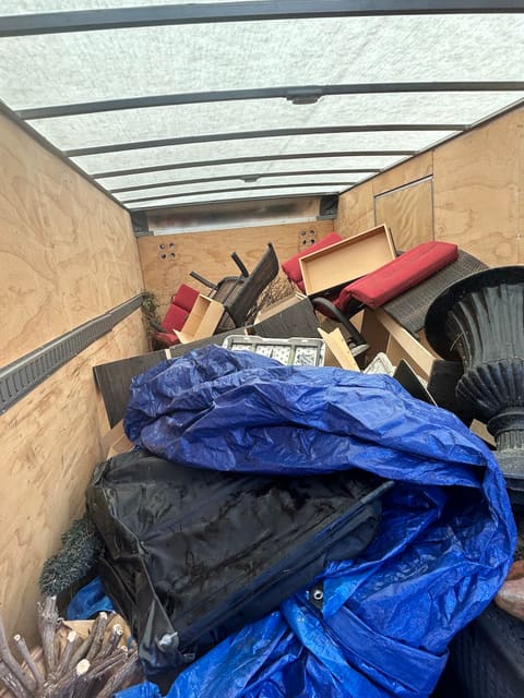 Tarps, wood and household junk loaded in a truck