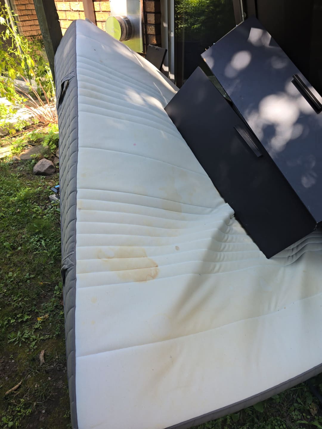 An old mattress and a dresser ready to be hauled away
