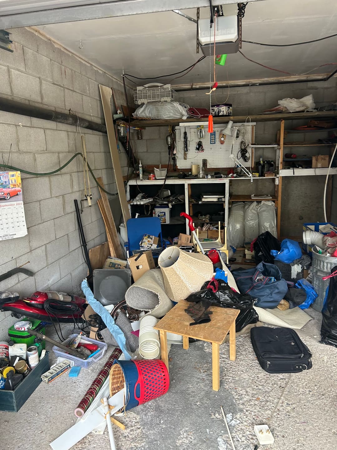 A packed garage full of tools, boxes and household items before a cleanout