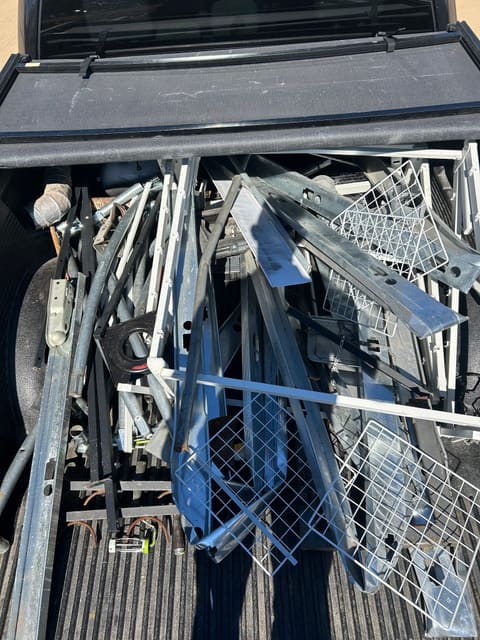 Metal shelving and wire racks loaded into a pickup truck bed